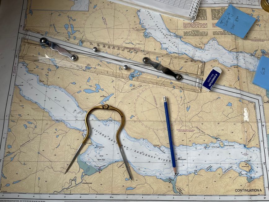 Flat lay of nautical chart with navigation tools including a compass, ruler, and pencil.